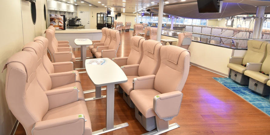 Elite Jet interior club seat with tables next to the bar